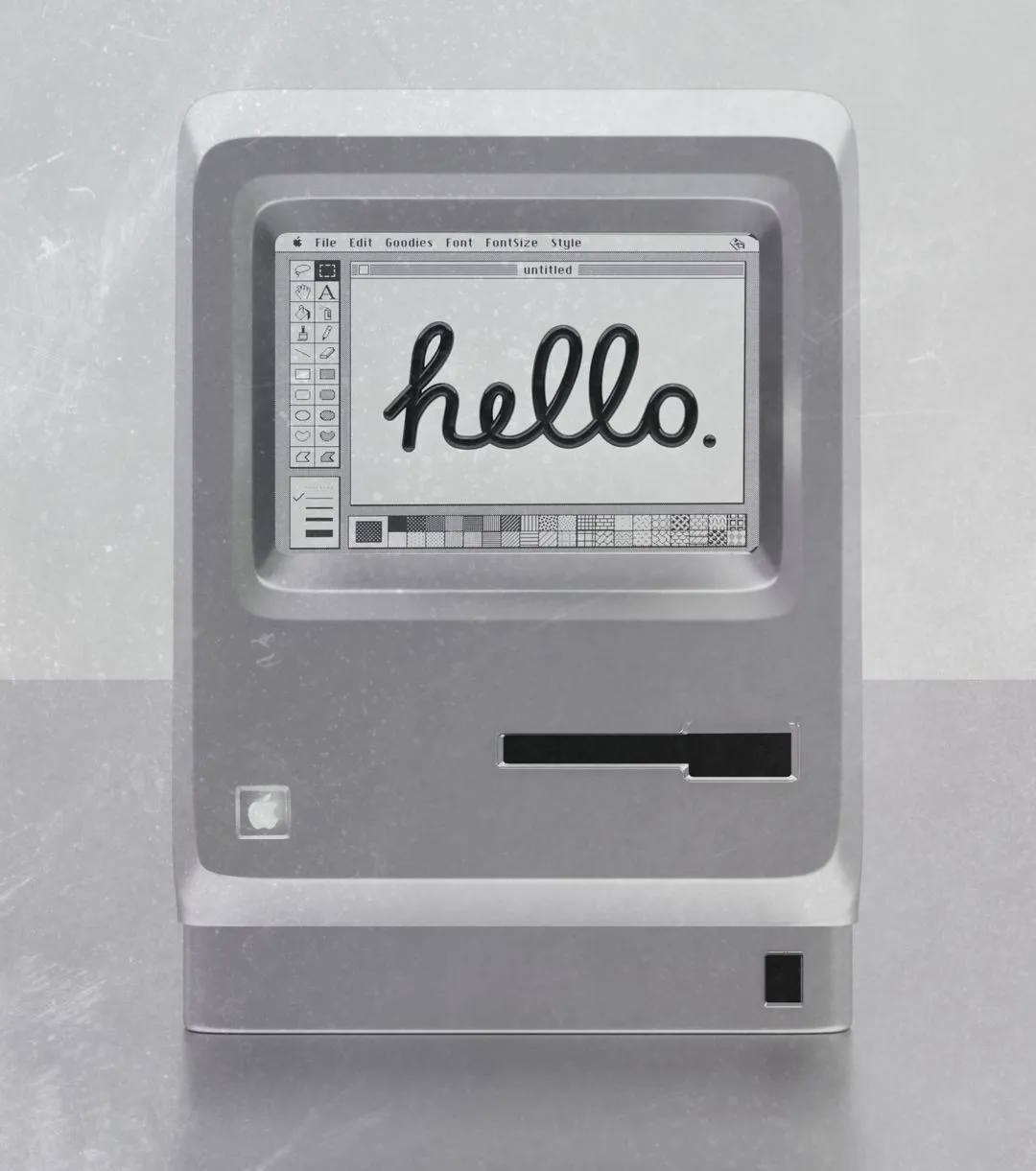 Vintage Macintosh computer displaying the word hello